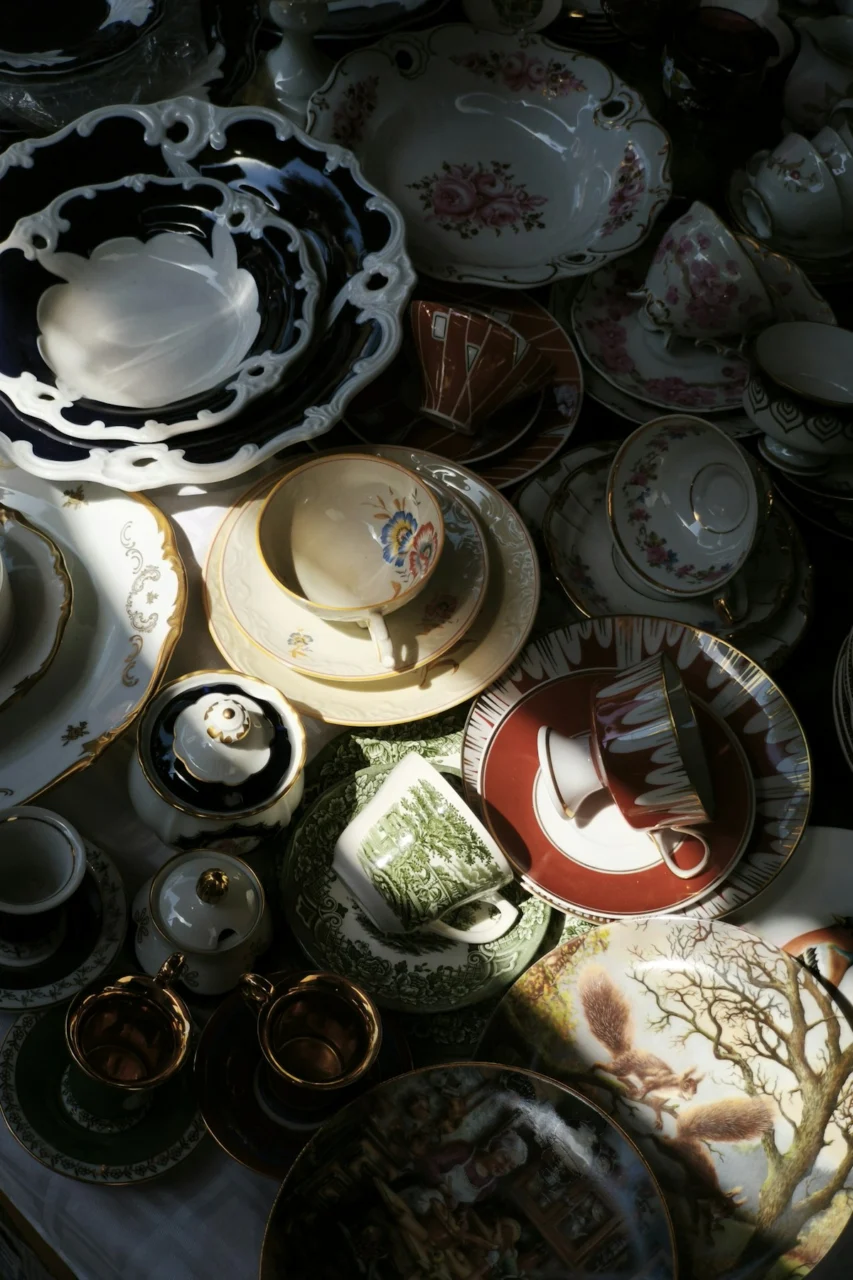 Various vintage teacups and plates are arranged closely together