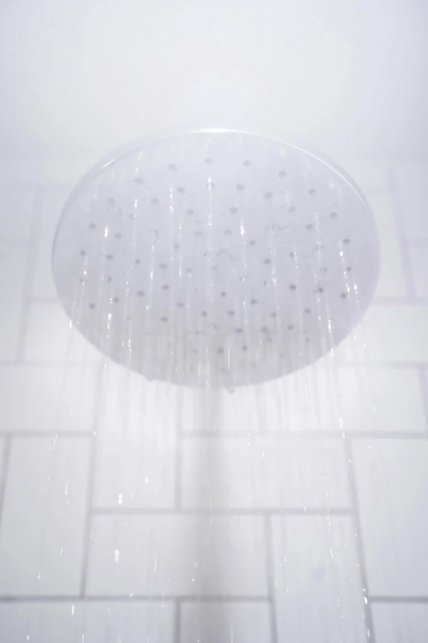 water from round gray stainless steel shower head