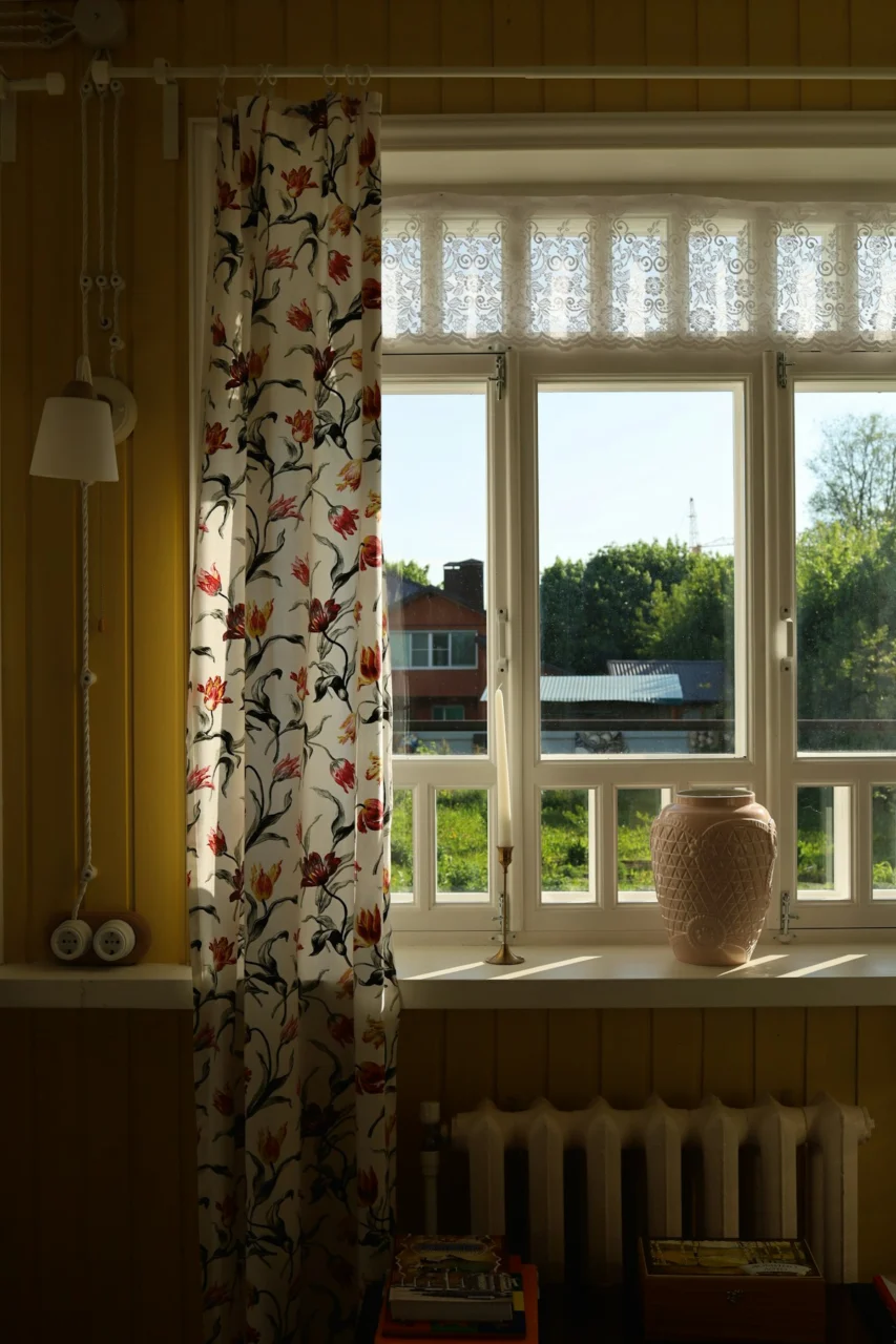 Window with floral curtains looking out into greenery