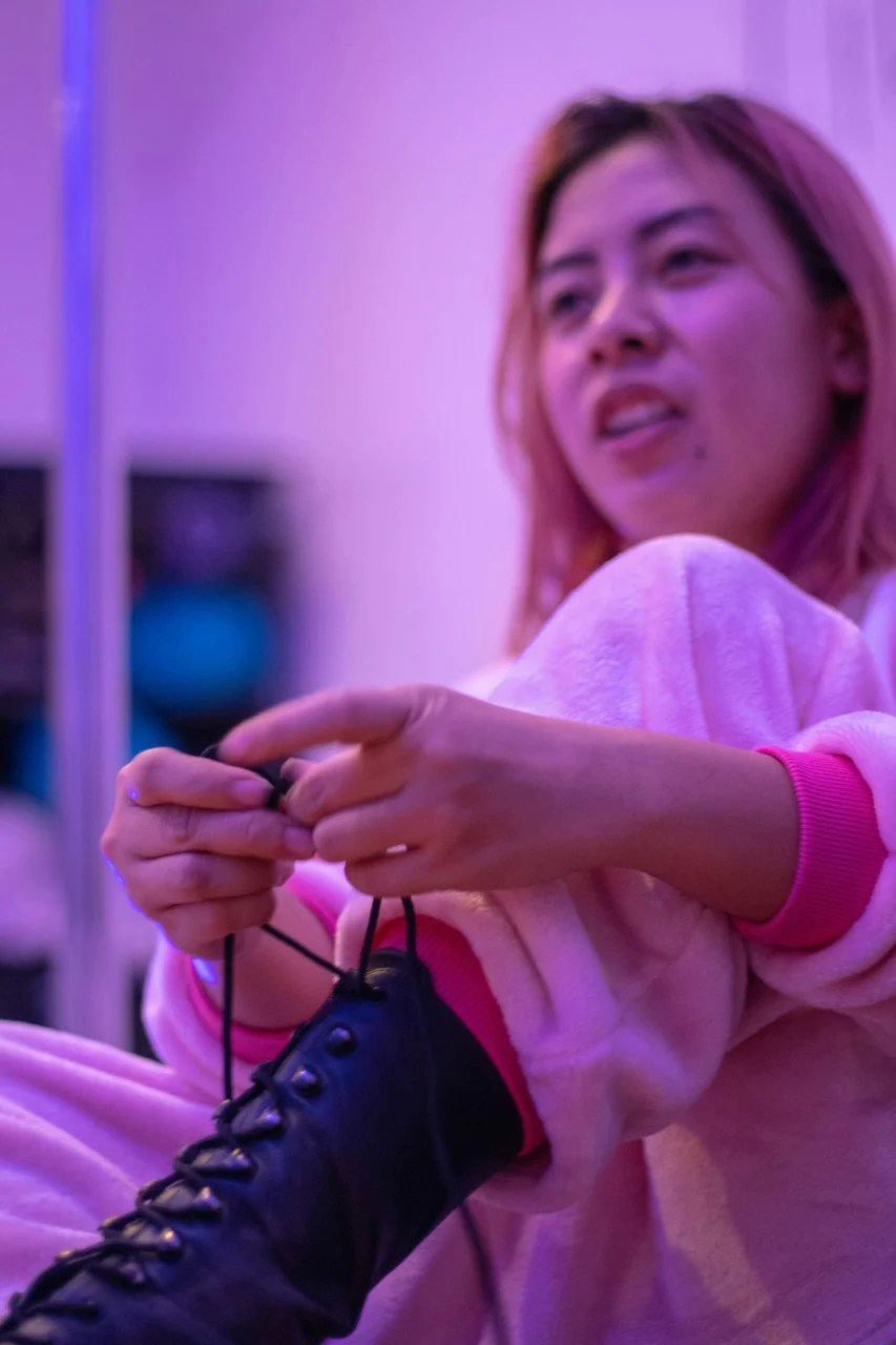 woman in pink sweater holding black leather bag