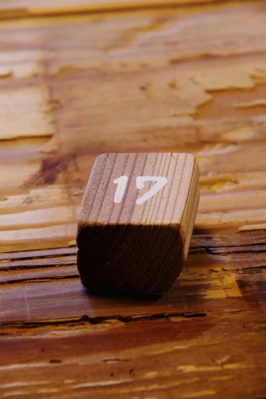 Wooden block with number 17 on a textured wooden surface