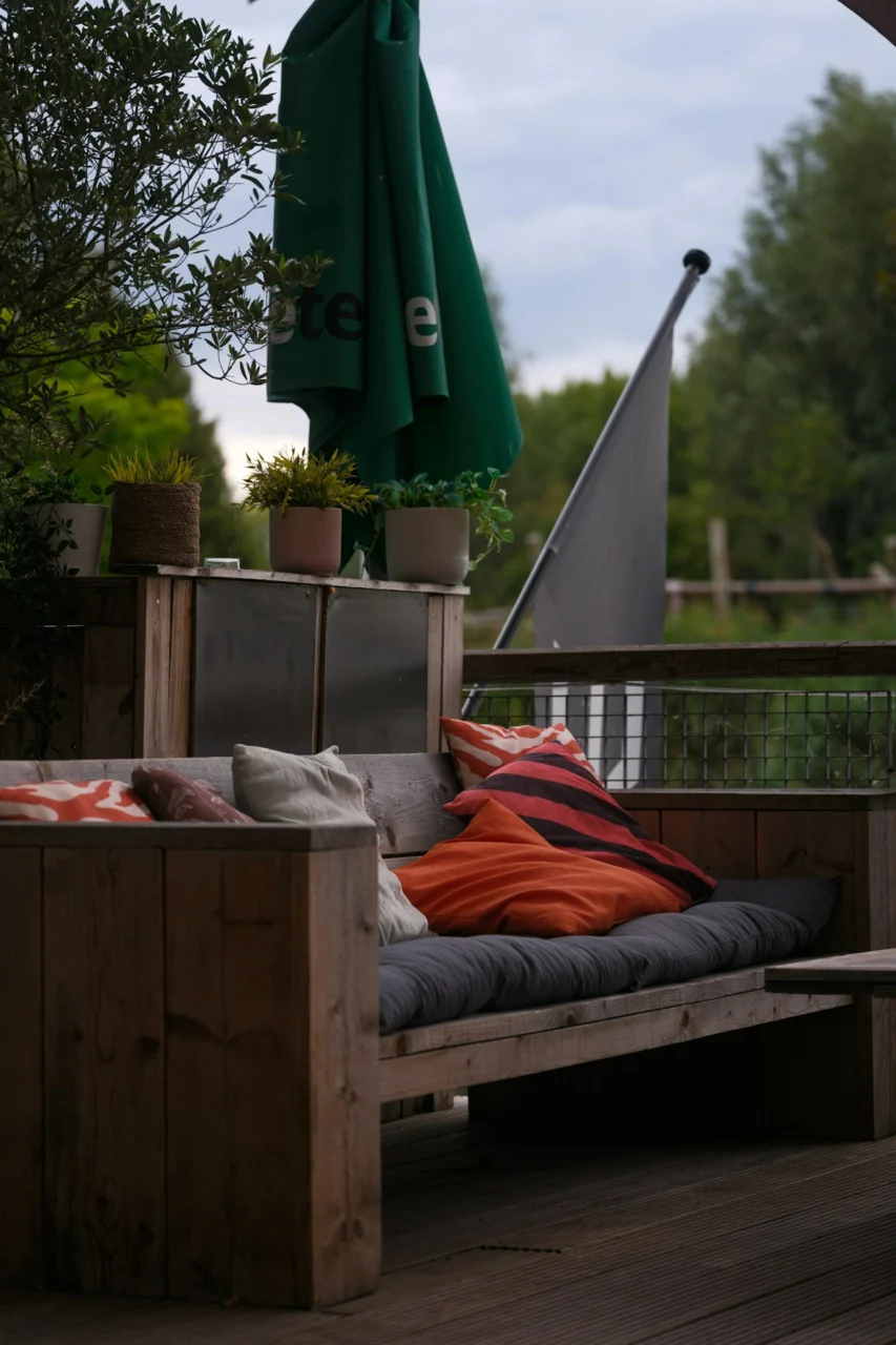 Wooden outdoor sofa with colorful pillows and striped pillows