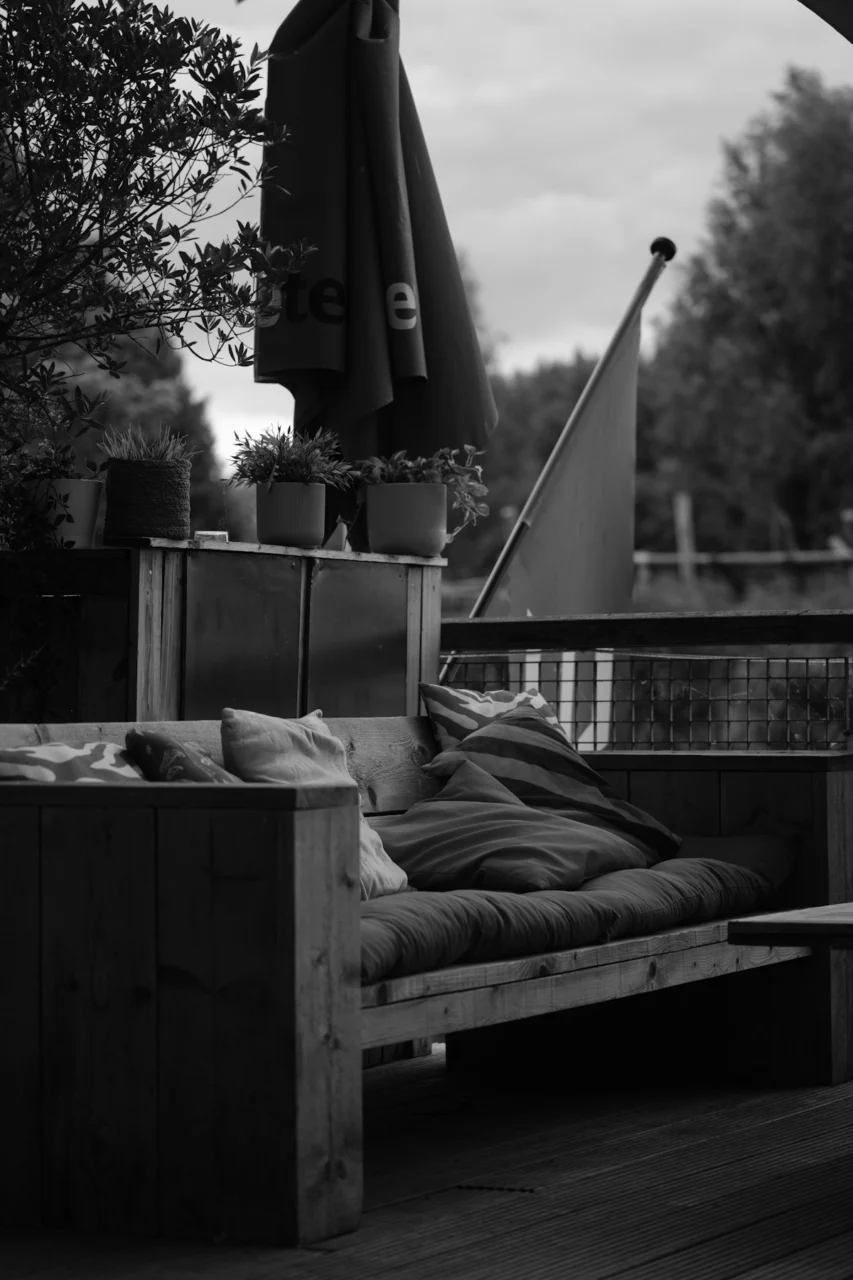 Wooden outdoor sofa with cushions and umbrella