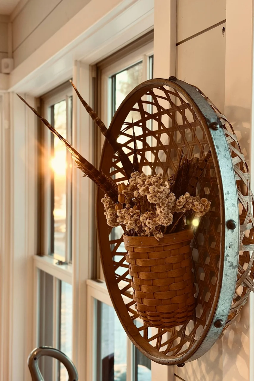 Woven wall basket with dried flowers and feathers